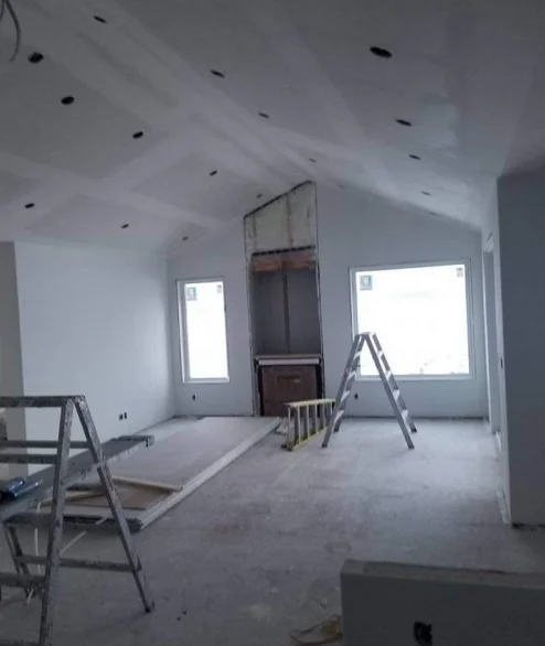 Vaulted living room with new drywall hung and taped on the walls and ceiling during a residential drywall project in Edmonton
